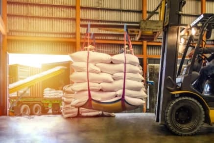 Forklift moving bulk bags of produce inside a warehouse