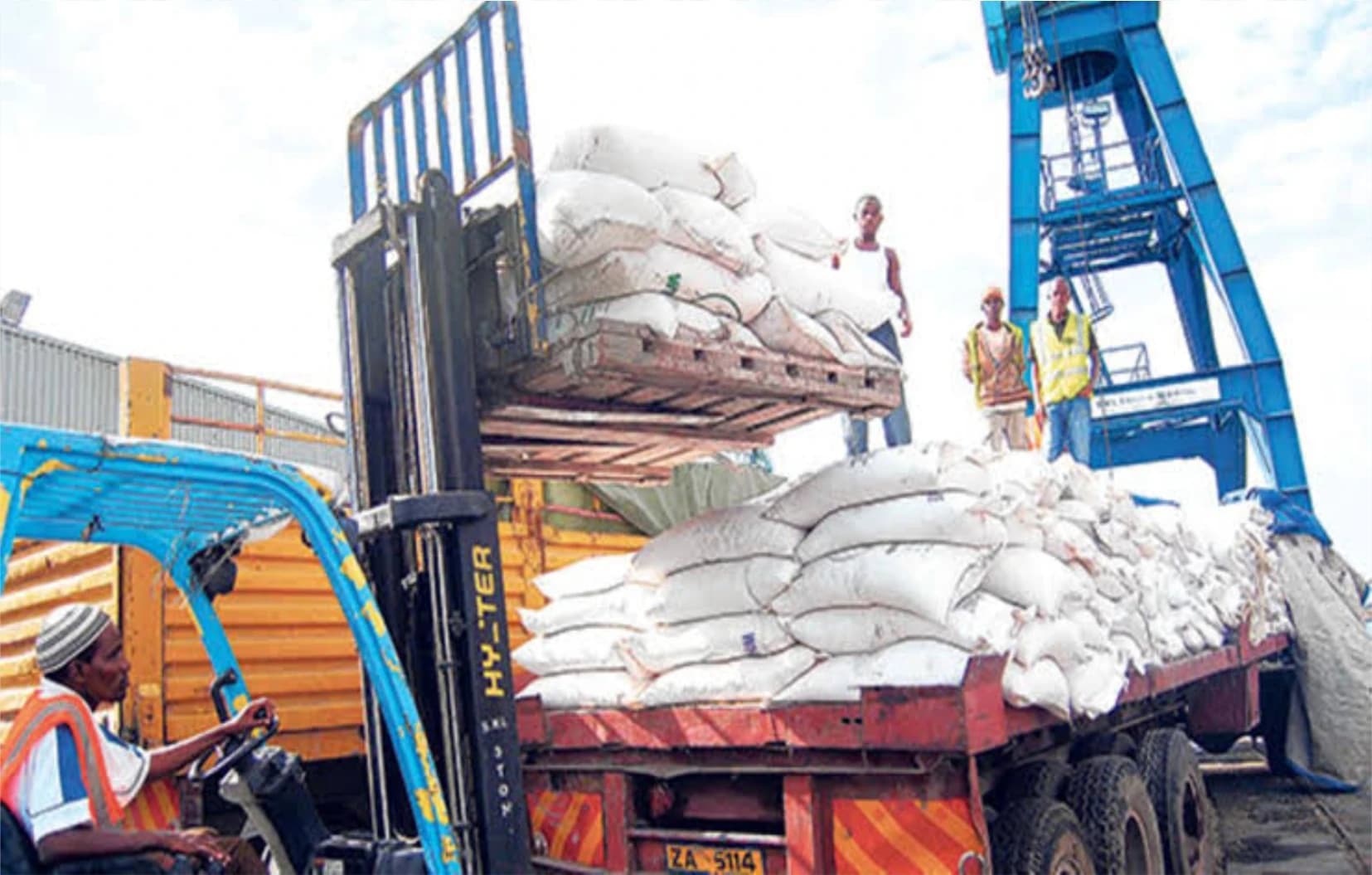 Forklift lifting a pallet of sacks onto a loaded truck